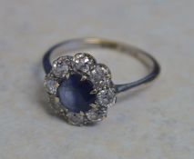 18ct gold daisy ring (previously white plated) set with central eight cut sapphire surrounded by