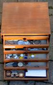 Small wooden 6 drawer cabinet containing watch parts, tools & small tins