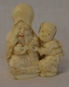 Carved ivory Meiji period netsuke depicting an old man & child H 4.5cm