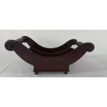 19th century mahogany cheese cradle of sleigh outline with movable divider on 4 small castors