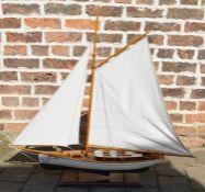 Modern model yacht with sail and rigging on fixed wooden stand, length of yacht 49cm