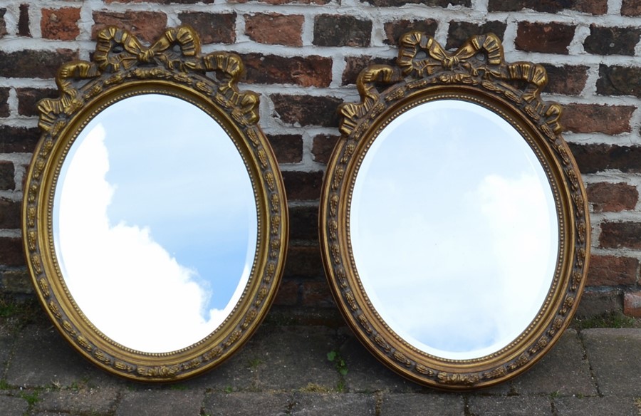 Pair of gilt oval wall mirrors