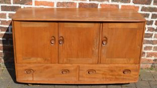 Ercol elm sideboard with interior cutlery drawer and three cupboard doors over two drawers raised on