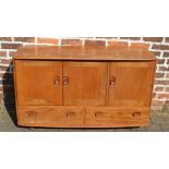 Ercol elm sideboard with interior cutlery drawer and three cupboard doors over two drawers raised on