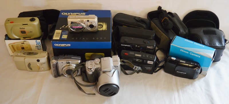 Various compact cameras including Lumix DMC-FZ5, Canon Powershot A720IS, Olympus U-410, Nikon Lite