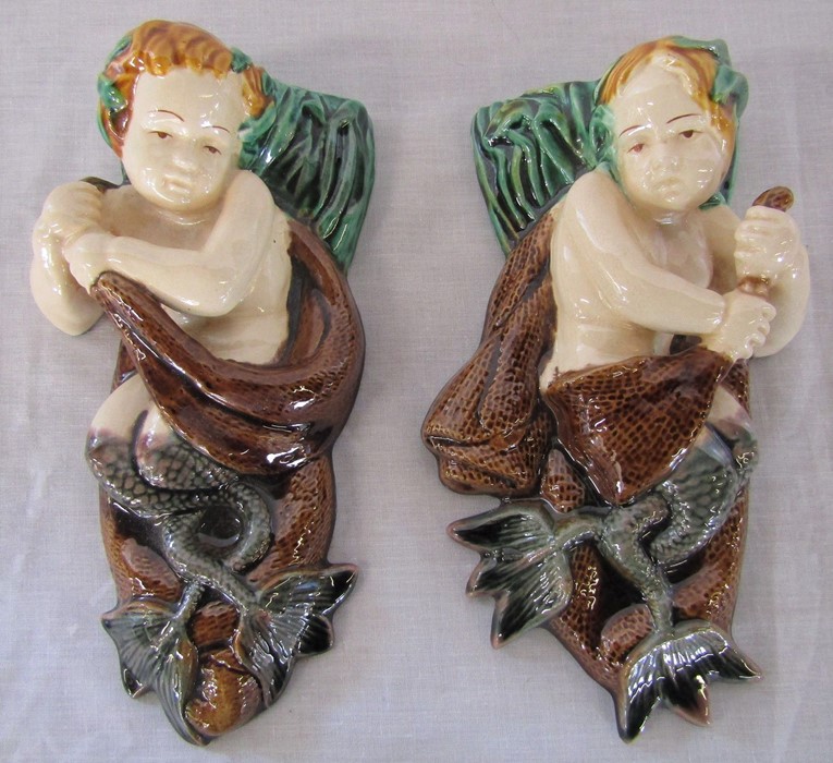 Pair of majolica wall pockets in the form of a merboy (some restoration to backs)