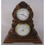 19th century walnut barometer and clock set carved with leaves and scrolls on a stepped plinth H