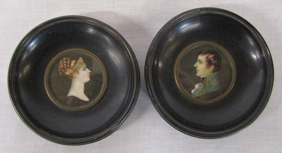 Reproduction portrait miniatures of a young man and woman in a black lacquered circular frames, both