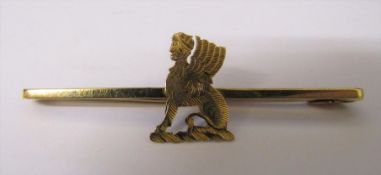 9ct gold stick brooch with yellow metal mythical creature centre piece total weight 2.5 g