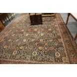 A Wilton carpet of traditional Persian design with all-over floral design on a dark ground in shades