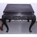 A Chinese carved and ebonised occasional table, on cabriole supports, 34" wide