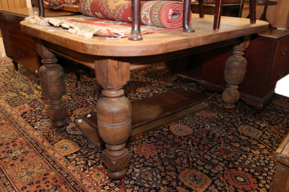 A late 19th century oak extending dining table, with two extra leaves, on cup and cover supports,