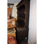 An oak dresser with open shelves over cupboards, on barley twist supports and open shelf, 54" wide