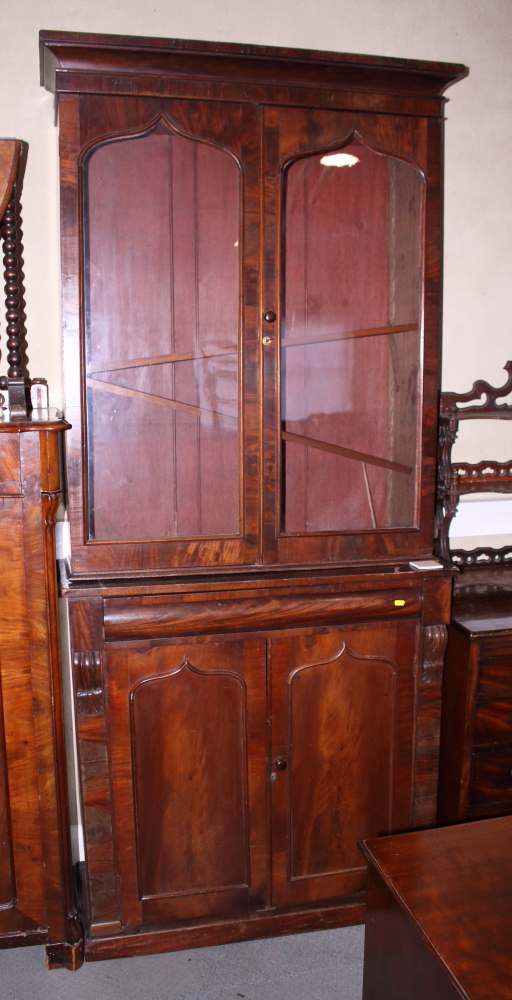 A George IV mahogany bookcase, the upper section enclosed Gothic arch top glazed doors over