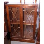 A walnut side cabinet enclosed astragal glazed panel doors, on block base, 33 1/2" wide