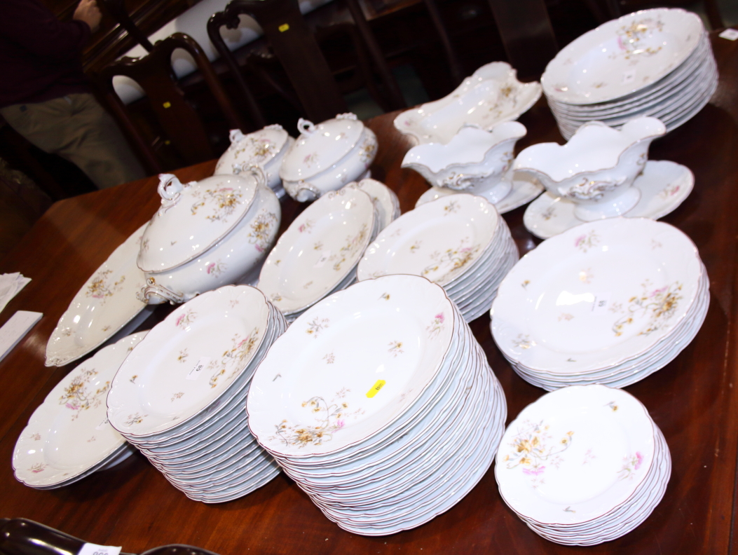 A Limoges porcelain floral and gilt decorated red bordered table service