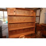 A pine open bookcase, fitted two cupboards, 44" wide, and a stripped pine open seven-tier wall