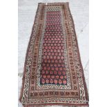 A Persian tribal runner with all over boteh design on a blue ground in shades of red, brown, green