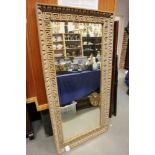 A 19th century stripped pine wall mirror with carved detail, 60" x 31"