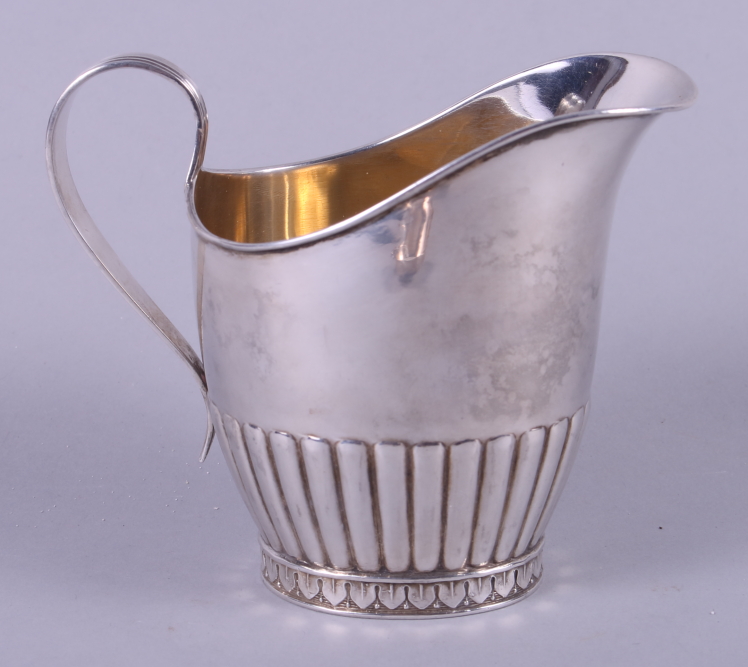 A Swedish silver cream jug with ribbed 'C' scroll handle and half-fluted decoration, on oval foot,