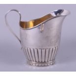 A Swedish silver cream jug with ribbed 'C' scroll handle and half-fluted decoration, on oval foot,