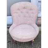 A late Victorian low seat nursing chair, button upholstered in an uncut moquette, on turned