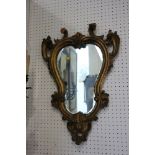 A carved giltwood scrollwork framed wall mirror, 25" high