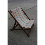 A 20th century oversized deck chair with striped canvas seat