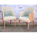 A pair of 1950s walnut elbow chairs, upholstered in a green moquette