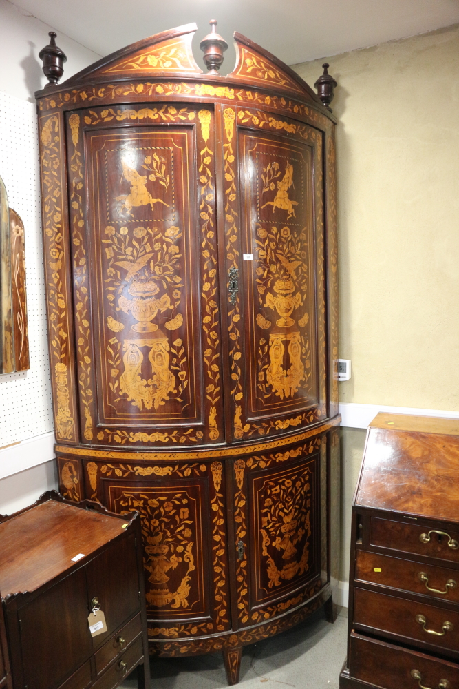 A Dutch marquetry bowfront corner cupboard with classical figures, vases of flowers, enclosed four