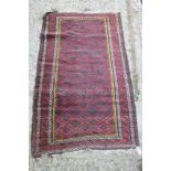 A tribal rug with trellis and lozenge design, in shades of plum, blue, brown, yellow and natural,