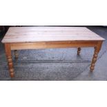 A waxed pine kitchen table, on turned supports, 35" x 72"