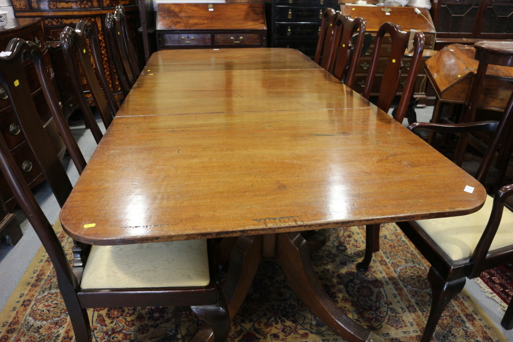 A George III design mahogany triple pillar dining table with two leaves, on reeded quadraform splay