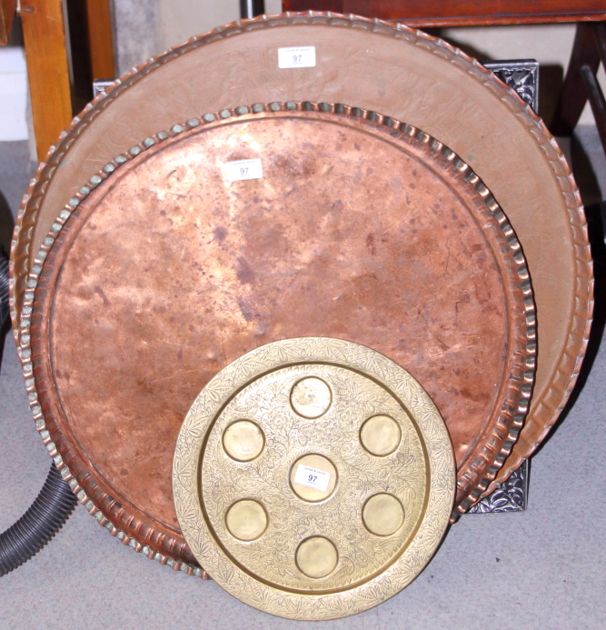 An Egyptian engraved copper tray, 25" dia, another, 22" dia, and a brass tray, 13" dia