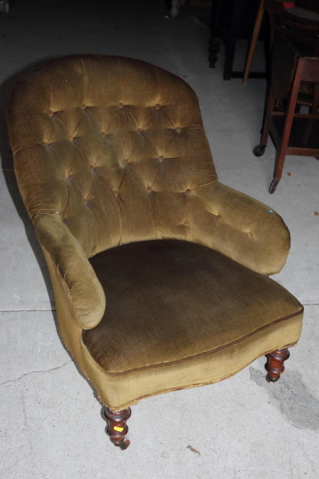 A Victorian low seat occasional chair, button upholstered in olive velour, on turned and