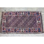 An early 20th century Bokhara rug with bands of star guls in shades of purple, blue, plum and black,