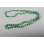 A graduated natural apple green jade bead necklace, with white metal clasp, 32" long