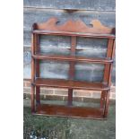 An early 19th century mahogany three-tier open wall shelf with shaped sides, 30" wide
