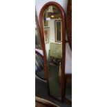 A mahogany framed arch top slip mirror, plate 51" x 9", and an oval wall mirror, in laid frame