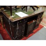 A late 19th century oak double pedestal desk with green leather tooled lined top, fitted two drawers