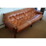 A 1960s hardwood frame settee with leather seat and back cushions