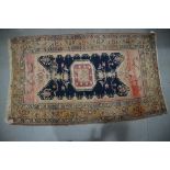 A Kazak design rug with central medal and birds on a dark blue ground, 68" x 47" approx (worn)