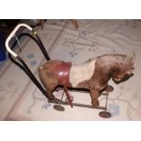 A child's early 20th century plush push-along horse, 24" long