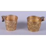 A pair of gilt metal replica ancient Greek mugs with embossed decoration