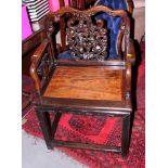 An antique Chinese carved hardwood splat back armchair with bat decoration and panel seat