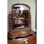 A mahogany arch topped swing frame dressing mirror, on barley twist supports and plateau base