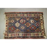 A Caucasian tribal rug with star-shape guls on a blue ground, 53" x 36" approx (worn)