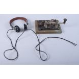 A Morse code key and a pair of headphones
