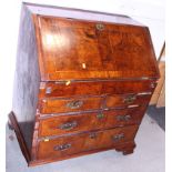 An early Georgian walnut and banded fall front bureau, the interior fitted drawers, pigeon holes and