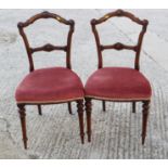 A pair of carved walnut bar back side chairs with stuffed over seats, on fluted supports